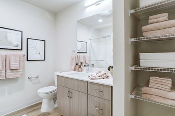 A bathroom with a toilet, sink, and towels.